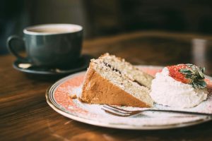A plate with cake and cup of coffee next to it