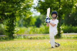 Child playing cricket in a park 