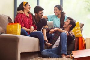 A group of students laughing on a sofa 