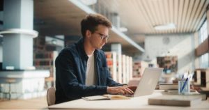 Man researching using laptop for Lincoln university application 